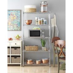 a kitchen shelving unit with pots and pans on the top shelf, next to a microwave