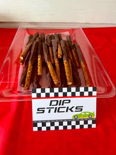 a plastic container filled with chocolate sticks on top of a red table