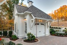 a white house with brick driveway and landscaping