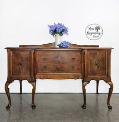 an old wooden dresser with flowers on top