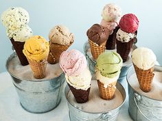 several ice cream cones in buckets on a table