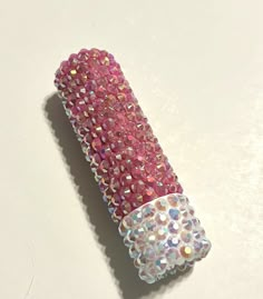 a pink and white object with lots of sparkles on it's side, sitting on a table