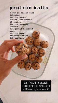 a hand holding a cookie doughnut in front of a plate with chocolate chip cookies on it