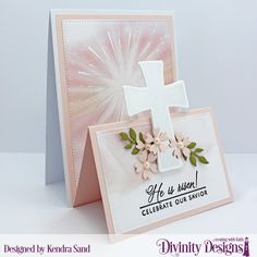 a greeting card with a cross and flowers on the front, in pastel pink