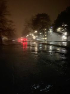 cars driving down the road at night on a rainy day