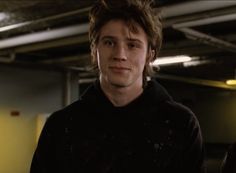 a young man standing in an empty garage