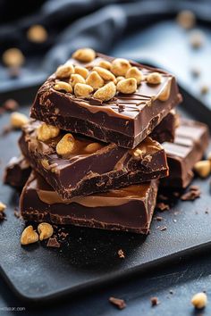 three pieces of chocolate with peanuts on top