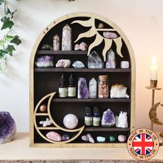 a wooden shelf filled with lots of different types of rocks and crystals next to a candle