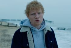 a man with red hair standing on the beach