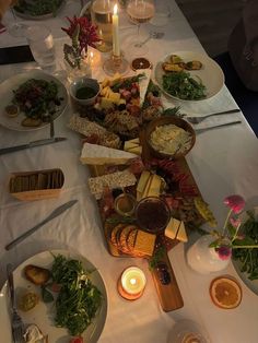 a table filled with lots of food and candles