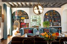 a living room filled with furniture and lots of books on the shelves next to a window