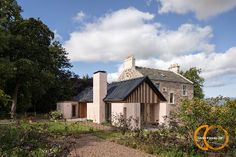 the house is surrounded by greenery and has a walkway leading up to it's front door