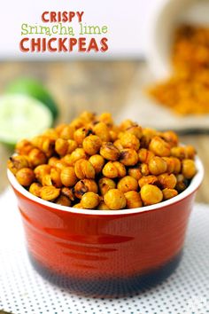 a red bowl filled with chick peas on top of a table