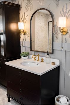 a bathroom with a sink, mirror and cabinet next to the bathtub in it