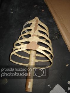 a large wooden object sitting on top of a black floor next to a cardboard box