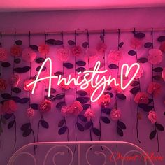 a neon sign that reads, anniston with flowers hanging from it's sides