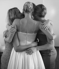 black and white photograph of three women hugging each other