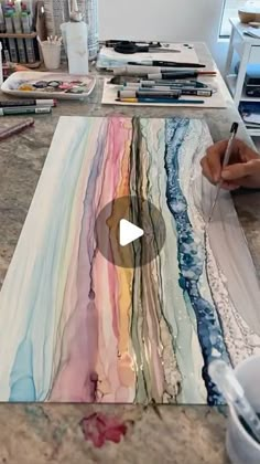 a person is painting on a table with paint