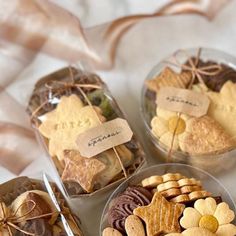 four small glass bowls filled with different types of cookies and crackers on a table