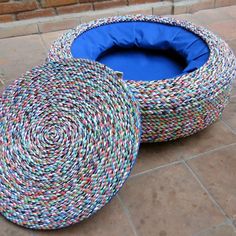 two round baskets sitting on the ground next to each other, one with a blue lid