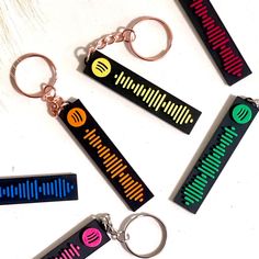 four keychains with different colored sound waves on them, one is black and the other is red