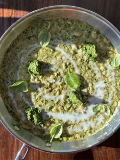 broccoli and white sauce in a pan on a wooden table