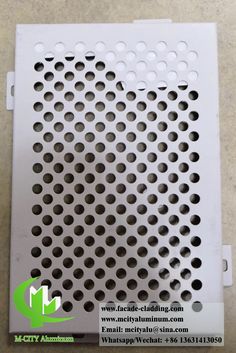 a metal grate with holes in it on the floor next to a white wall