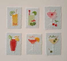 four cross stitch coasters with different drinks on them