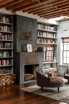 a living room filled with furniture and a fire place in front of a bookshelf