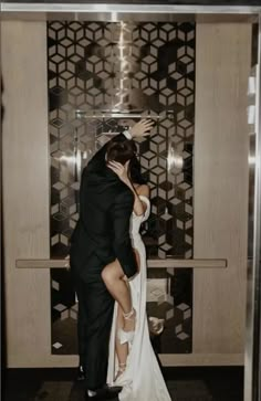 a bride and groom kissing in an elevator