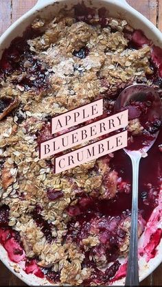 an apple blueberry crumble is in a dish with a spoon