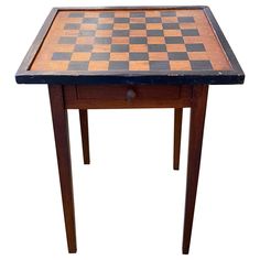 a wooden table with a checkerboard pattern on the top and drawer at the bottom