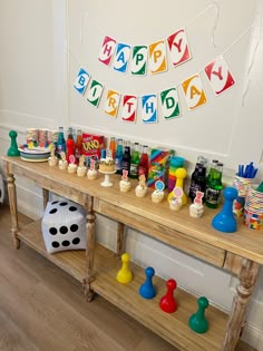 a wooden table topped with lots of toys and games on it's sides next to a white wall