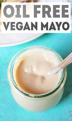 a jar filled with mayonnaise sitting on top of a blue table next to a plate