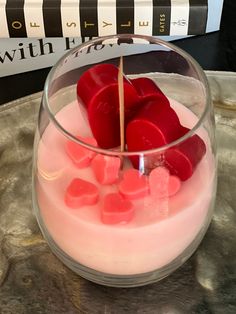 a bowl filled with candy and marshmallows on top of a table next to a stack of books