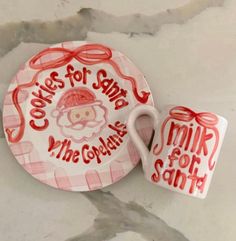 a plate and cup with the words cookies for santa written on it next to each other