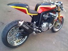 a red, yellow and black motorcycle parked in a parking lot