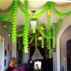 some green plants hanging from the ceiling above a table with purple cloths on it