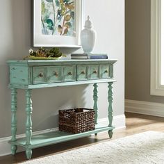 a blue console table with drawers and baskets on it next to a white rug in a living room