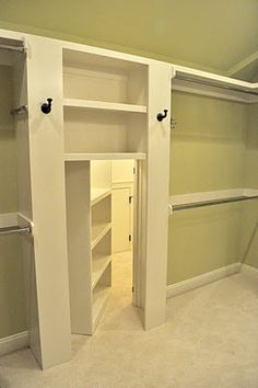 an empty walk in closet with white shelves and doors open to reveal another room that has no furniture