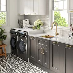 a washer and dryer sitting in a kitchen next to a window with potted plants