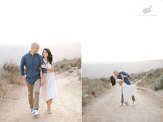 a man and woman walking down a dirt road holding each other's hands in the air