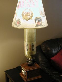 a lamp that is sitting on top of a table next to a black leather couch