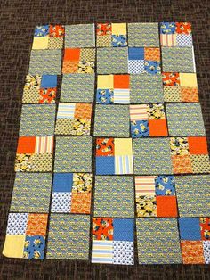 a patchwork quilt is laid out on the floor