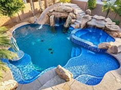 a backyard pool with a waterfall and slide