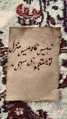 an old piece of paper that has been written in persian script on top of a rug