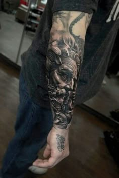 a man with a black and grey tattoo on his arm