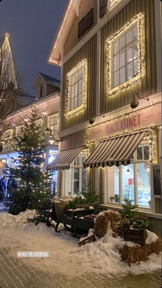 a building with christmas lights on the windows and decorations around it's front window