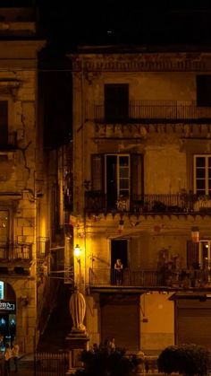 an old building with balconies lit up at night