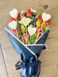 a bouquet of strawberries, blueberries, oranges and chocolate hearts